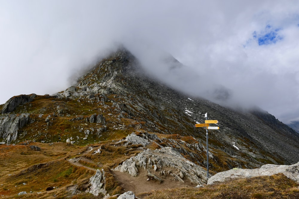 a very tall mountain with a sign in the foreground