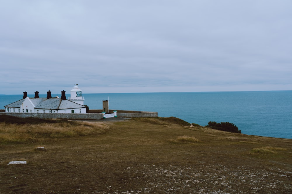 Una casa bianca seduta sulla cima di una collina vicino all'oceano