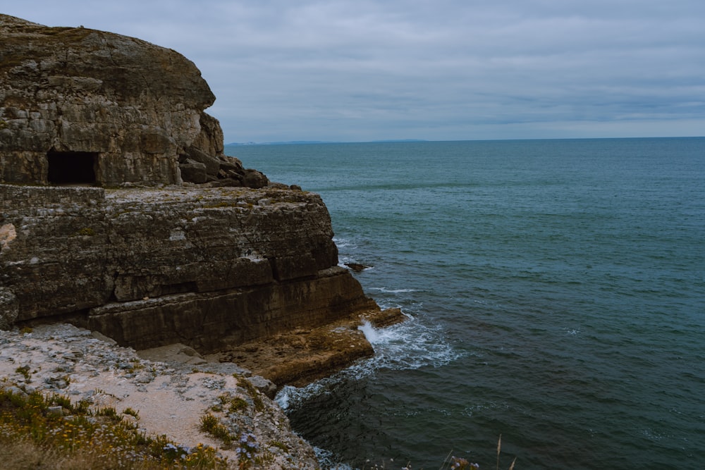 a rocky cliff overlooks a body of water