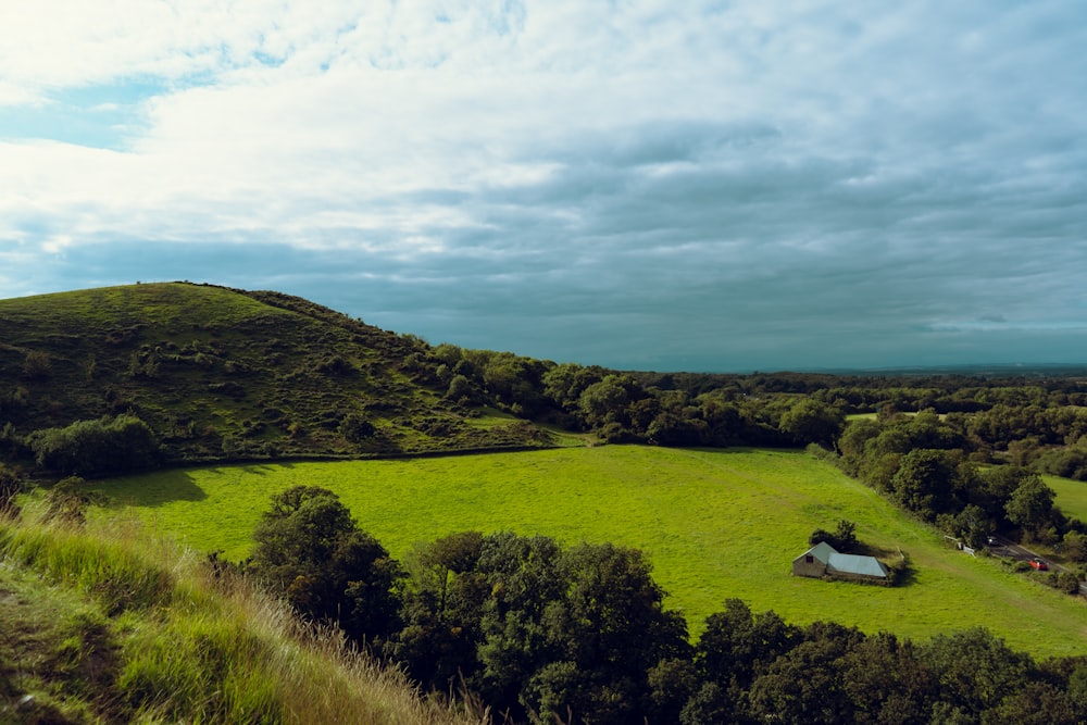 una veduta aerea di un campo verde con una casa su di esso