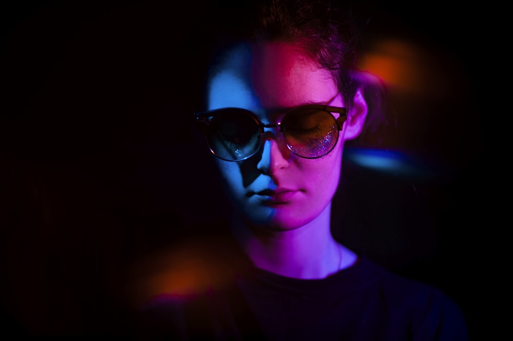 Une femme portant des lunettes de soleil dans une pièce sombre