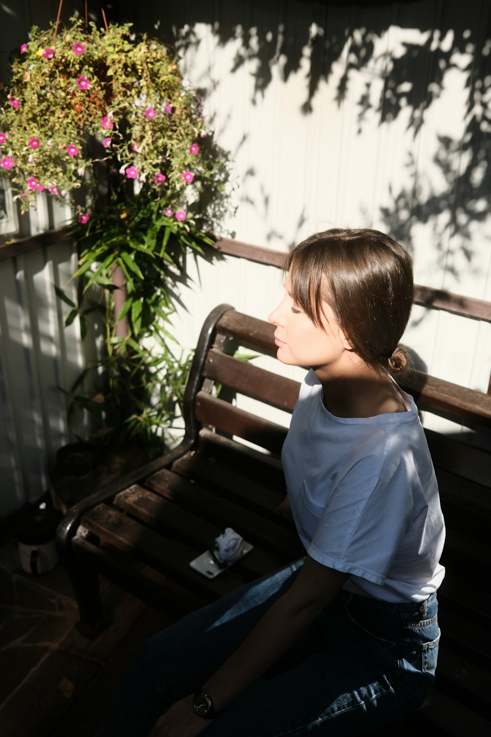 a young girl sitting on a wooden bench