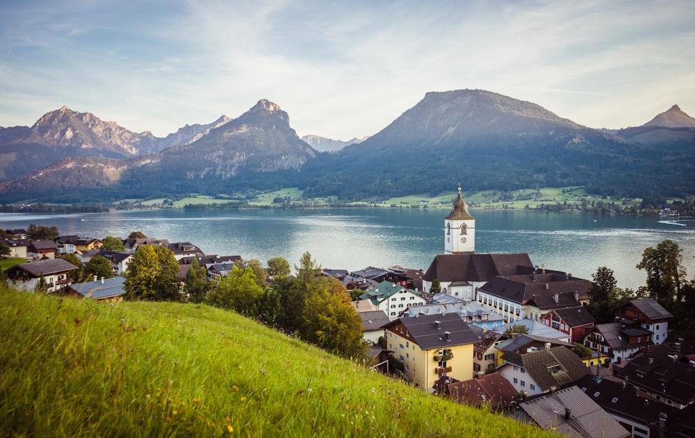 a scenic view of a town with mountains in the background