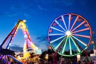 a ferris wheel and a ferris wheel lit up at night
