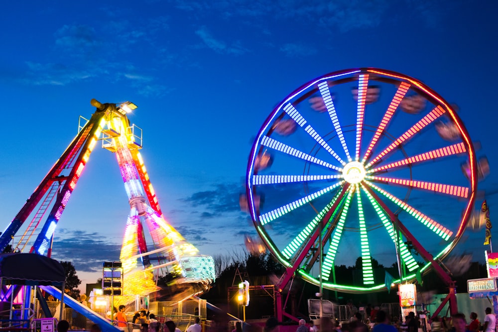 a ferris wheel and a ferris wheel lit up at night