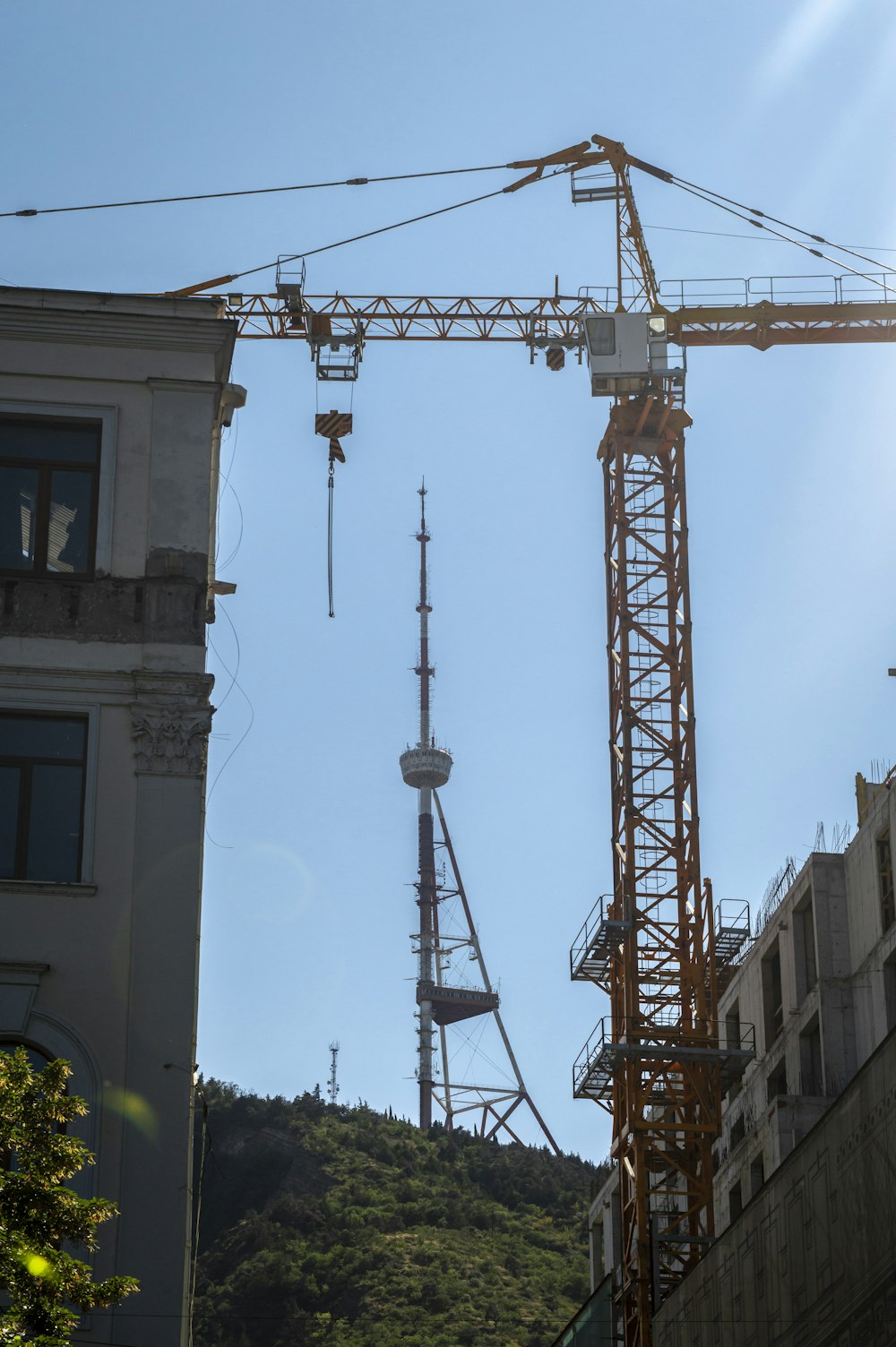 Una grúa está parada frente a un edificio