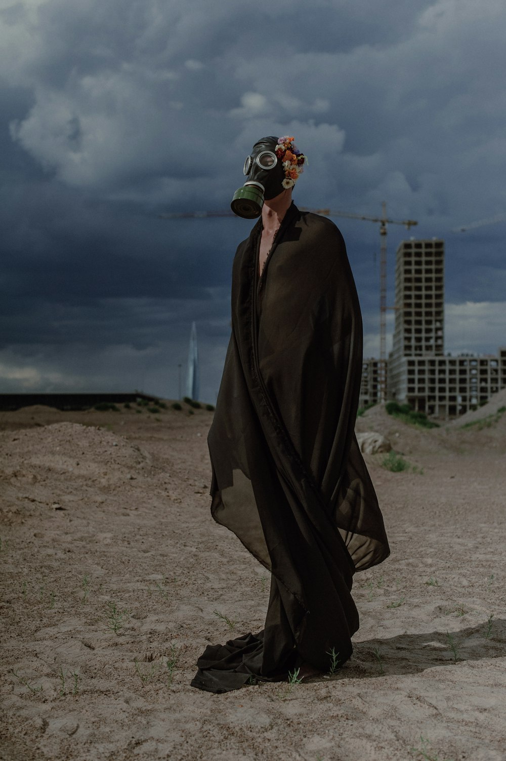 a man with a mask on standing in the sand