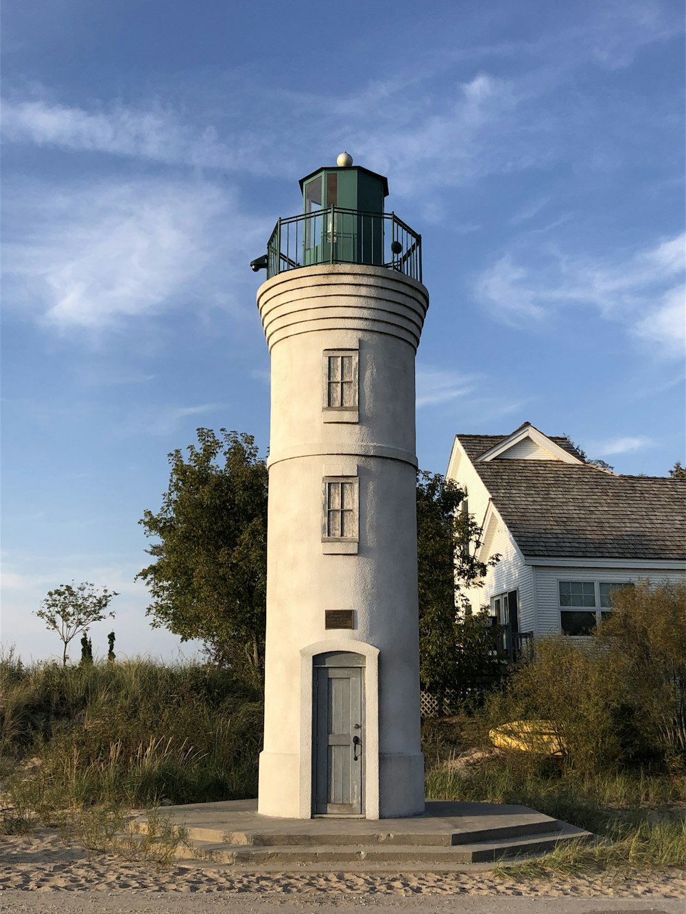 a white lighthouse sitting on top of a sandy beach