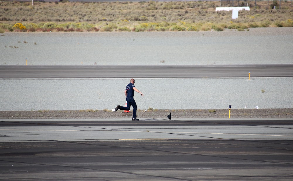 a man running across an airport tarmac