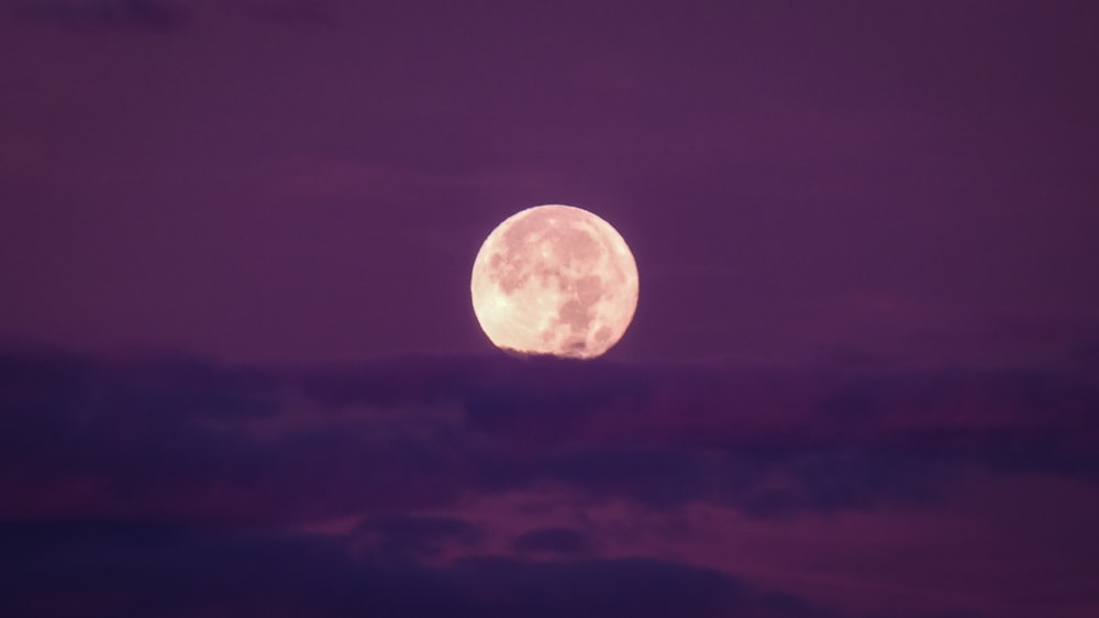 uma lua cheia é vista no céu noturno