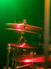 a drum set up in front of a green light