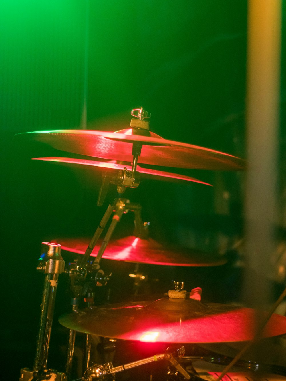 a drum set up in front of a green light
