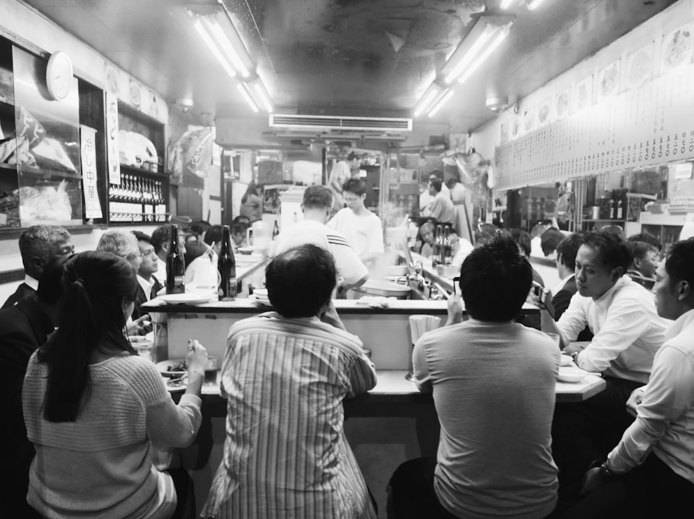 a group of people sitting around a table in a restaurant