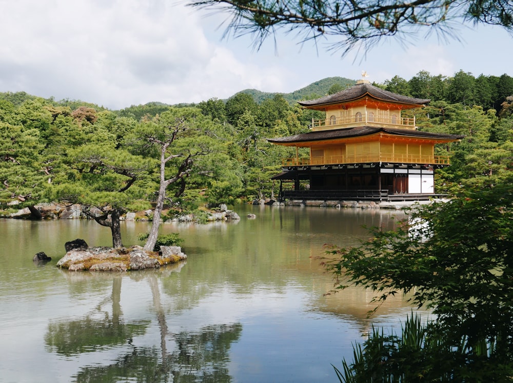 a pagoda in the middle of a lake surrounded by trees