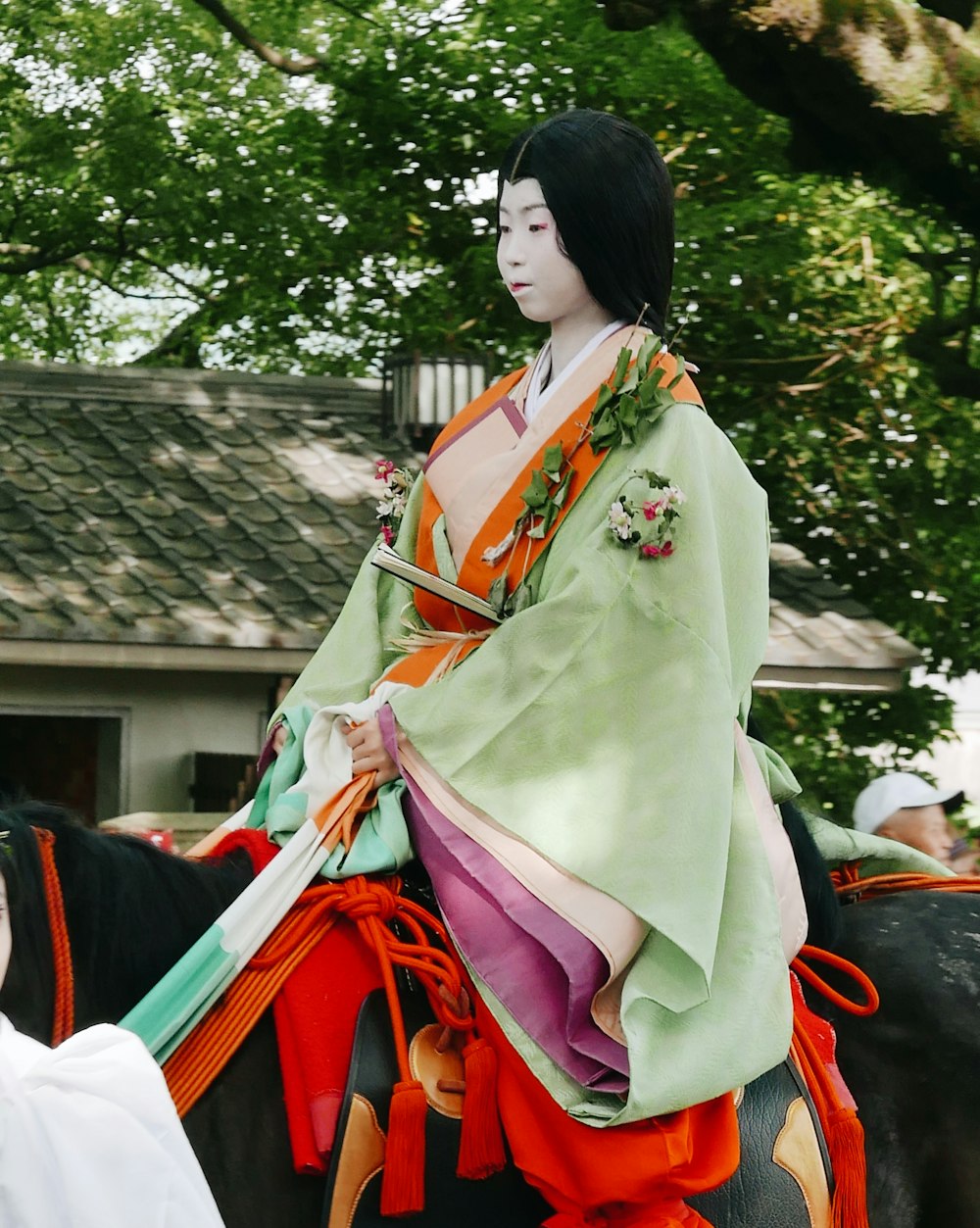 a woman in a kimono riding a horse