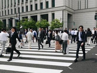 a group of people walking across a cross walk