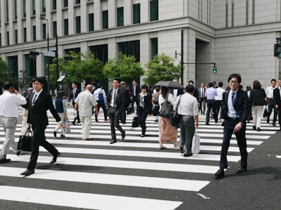 a group of people walking across a cross walk