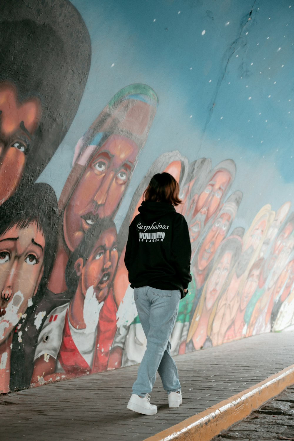 a person standing in front of a mural
