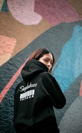 a woman standing in front of a colorful wall