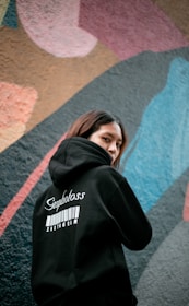 a woman standing in front of a colorful wall