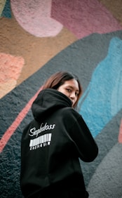 a woman standing in front of a colorful wall