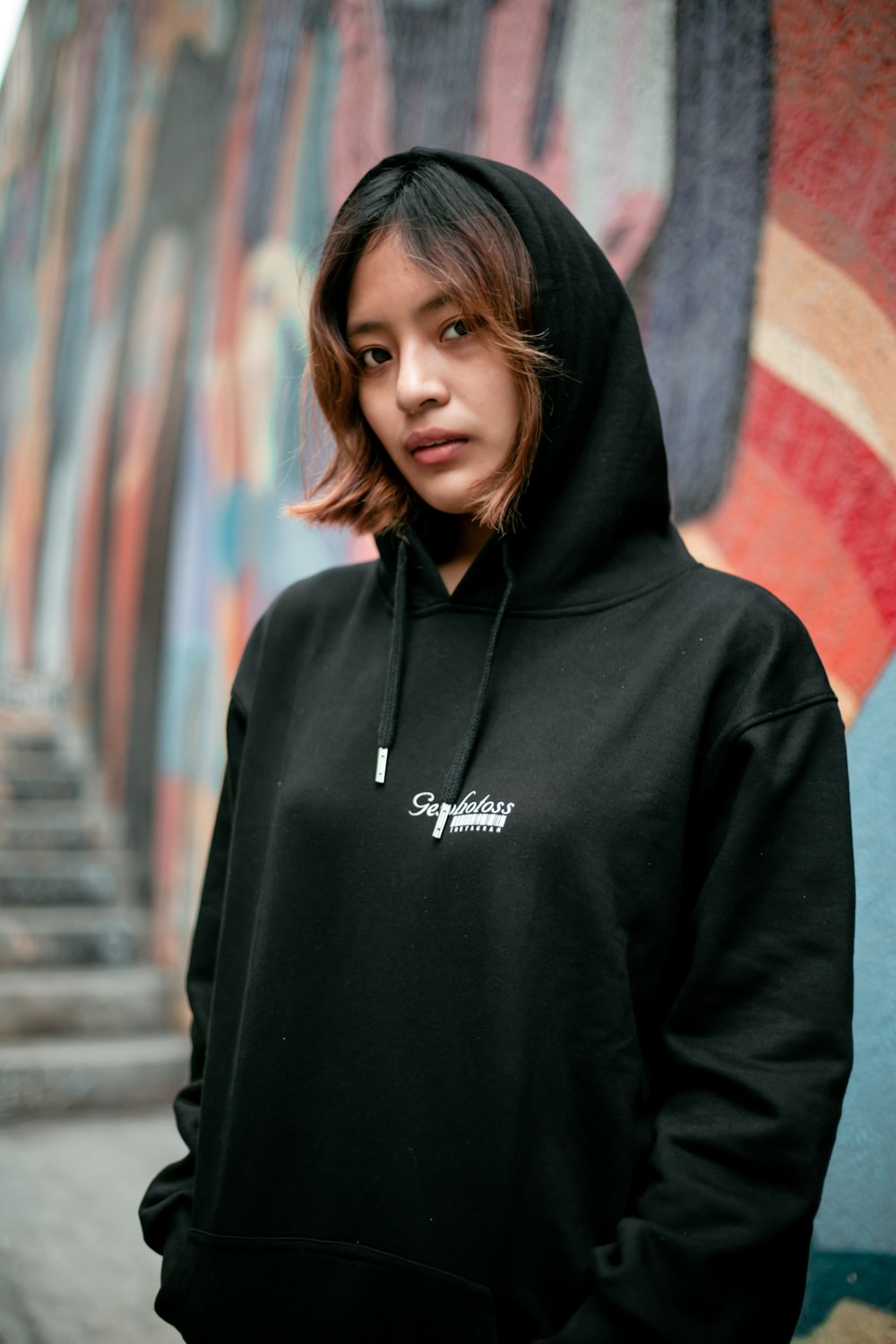 a woman standing in front of a wall with graffiti