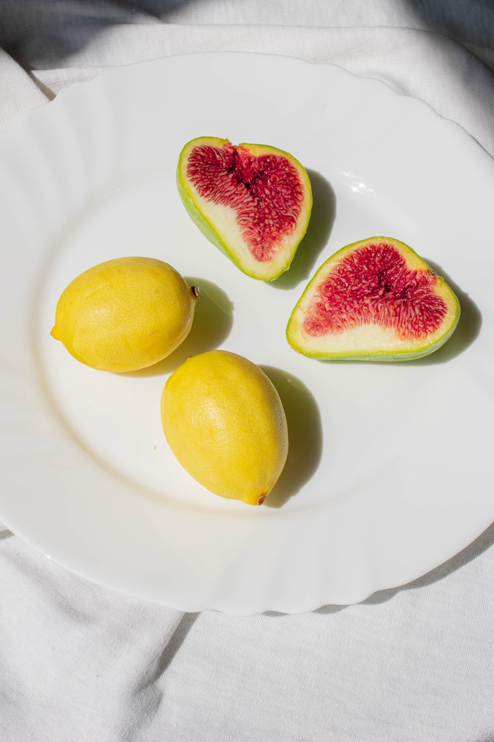 um prato branco coberto com três pedaços de fruta