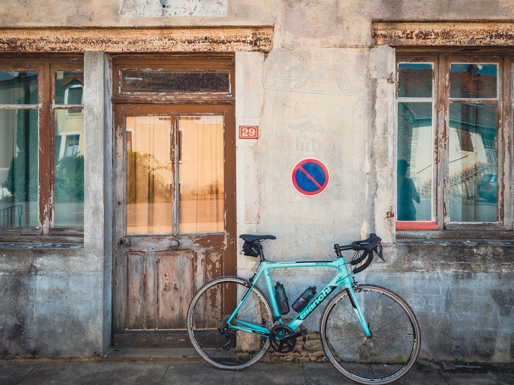 Una bicicletta blu parcheggiata di fronte a un edificio