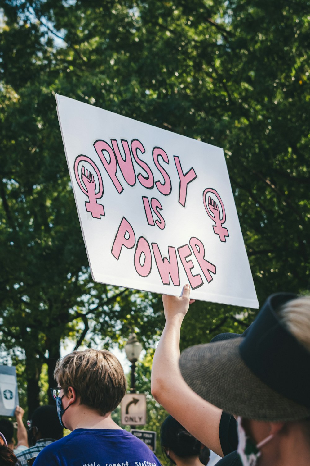 a person holding a sign that says pussy is power