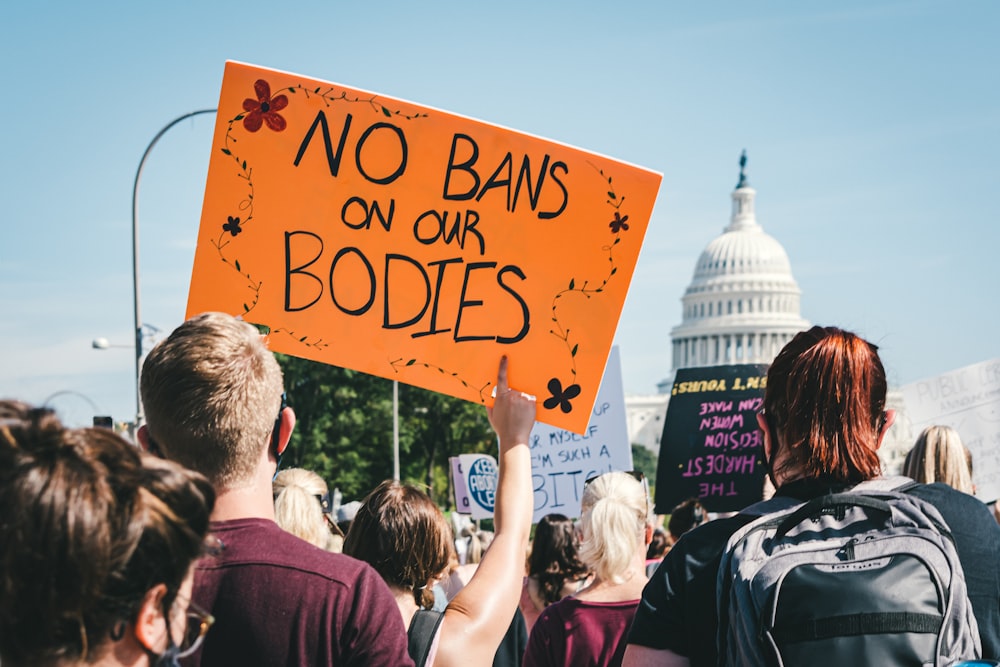 a group of people holding signs in front of the capitol building