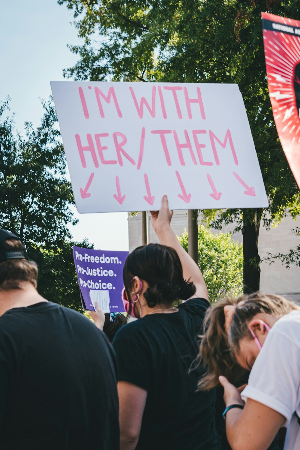 a group of people holding a sign that says i'm with her / them