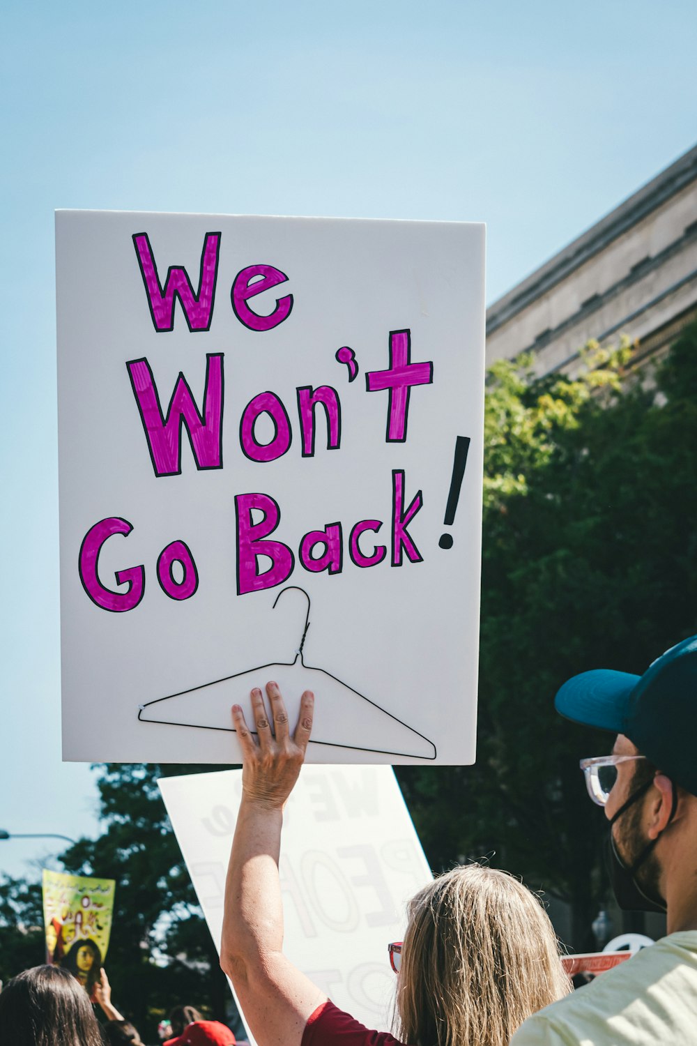 a man holding a sign that says we won't go back