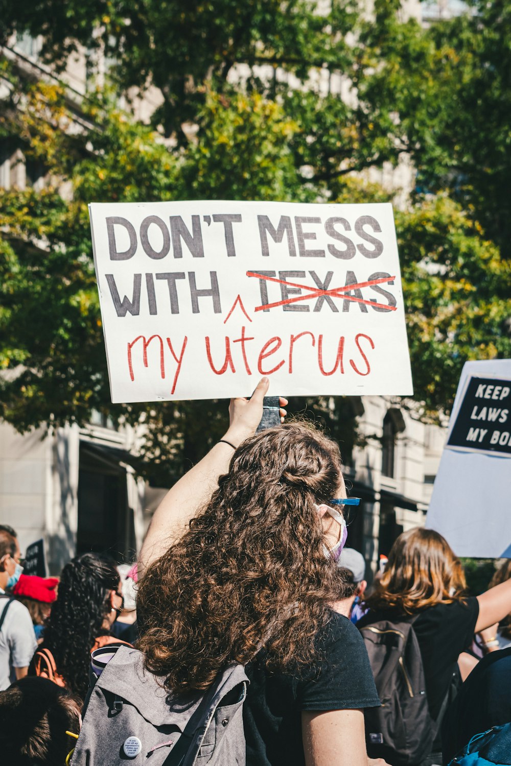 a woman holding a sign that says don't mess with texas my uter
