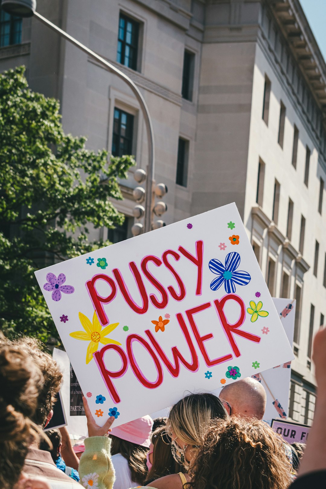 a person holding a sign that says pussy power