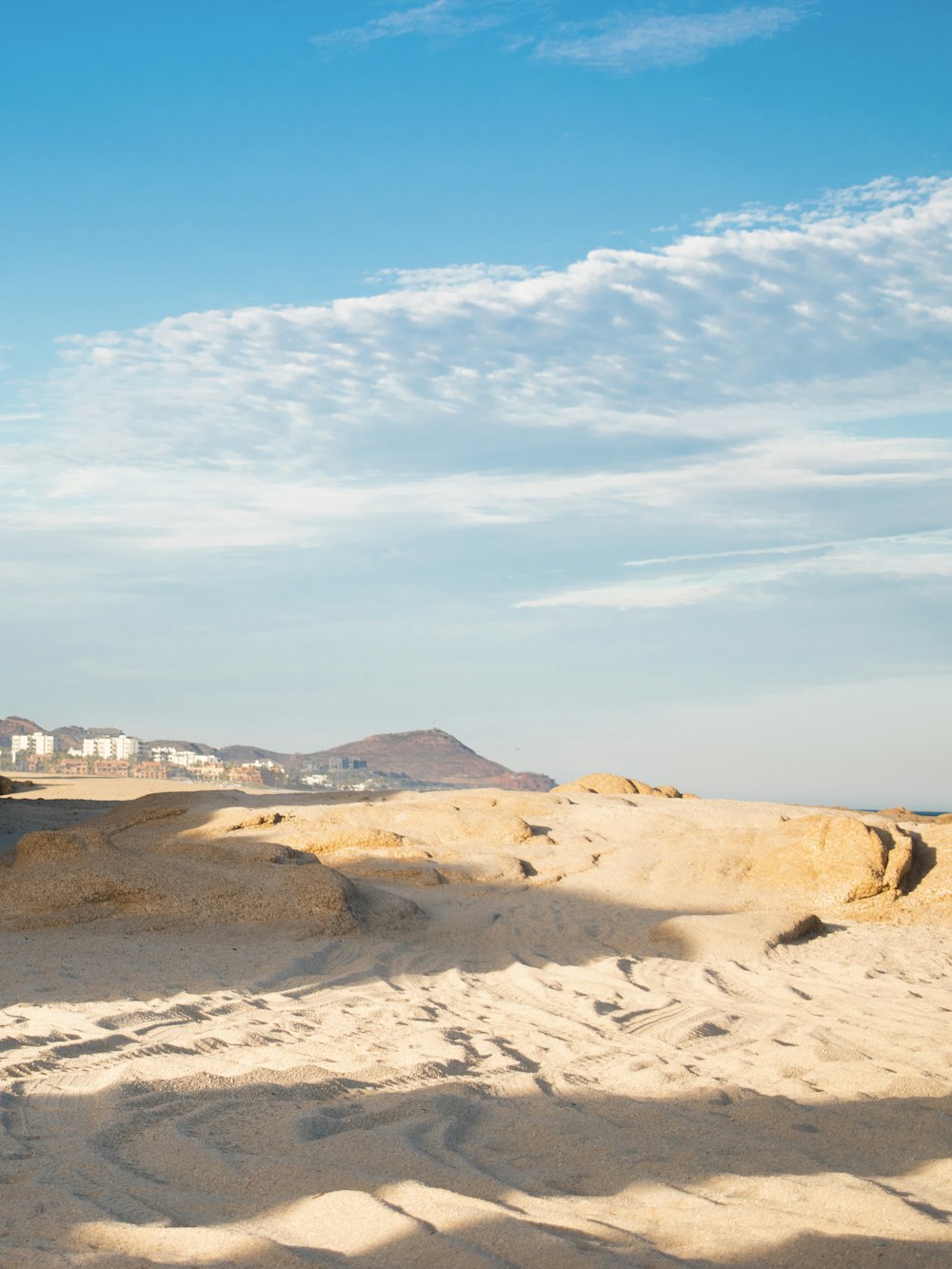 a man riding a surfboard on top of a sandy beach