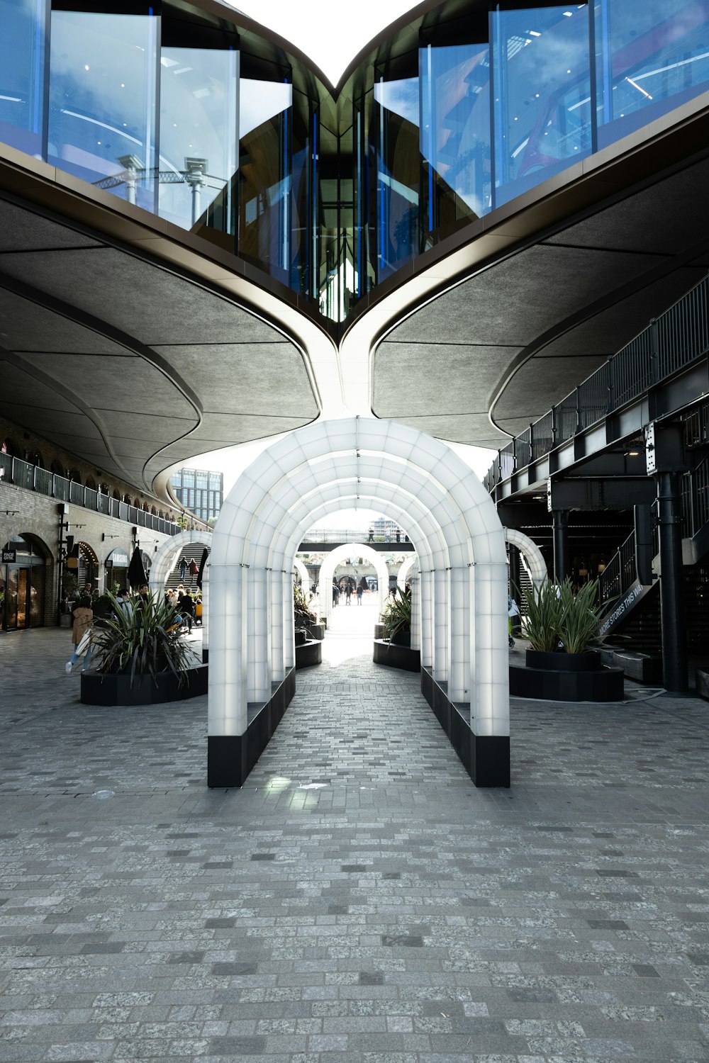 a walkway in a shopping center with a curved walkway