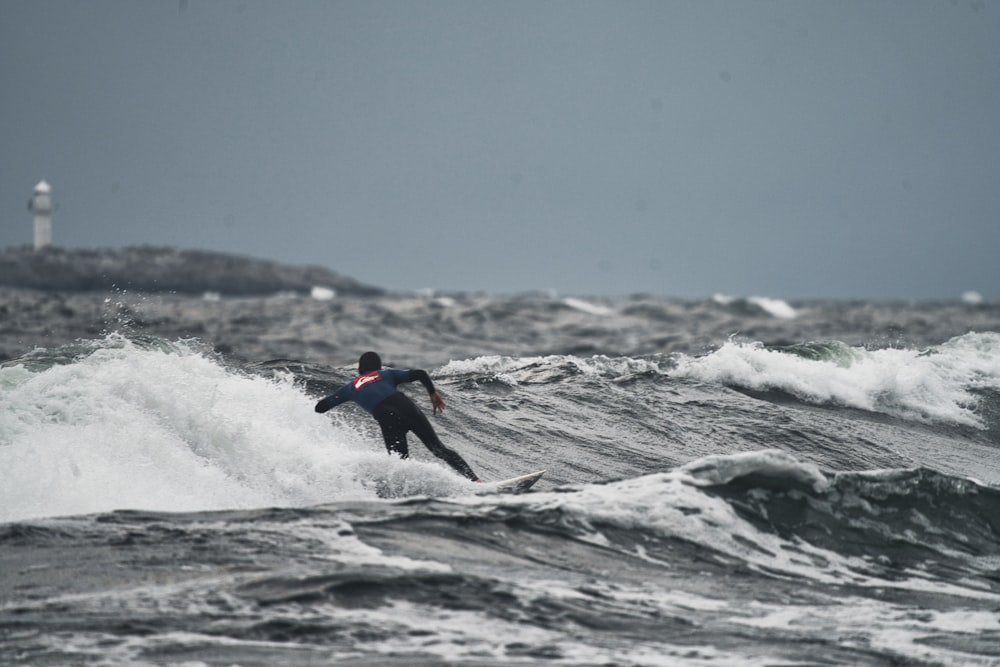 a man riding a wave on top of a surfboard