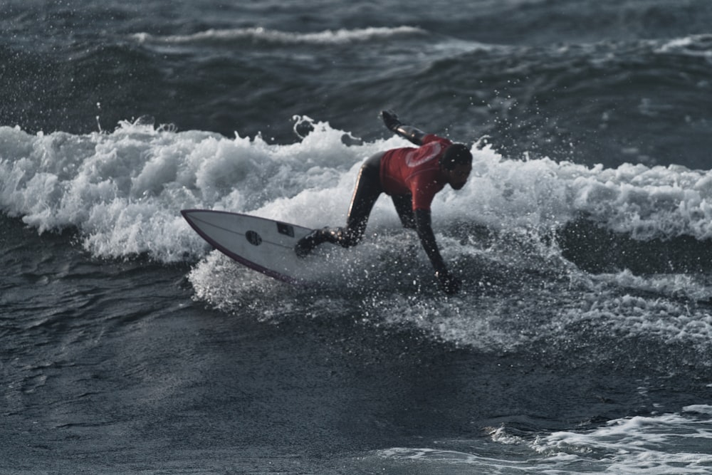 a man riding a wave on top of a surfboard