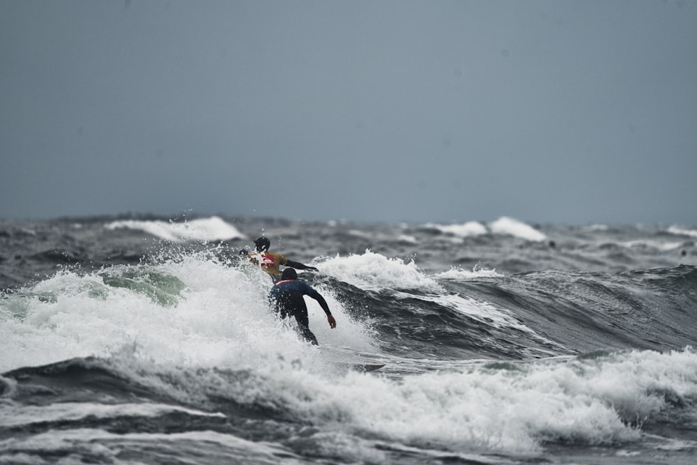 a man riding a wave on top of a surfboard