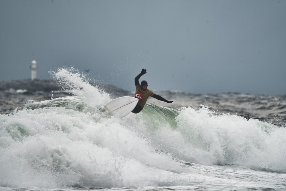 a man riding a wave on top of a surfboard