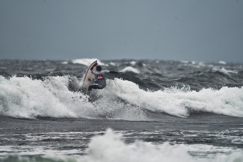 a man riding a wave on top of a surfboard