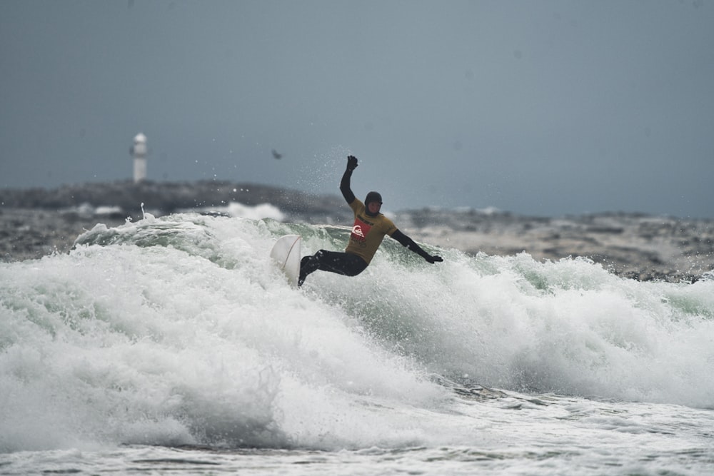 a man riding a wave on top of a surfboard