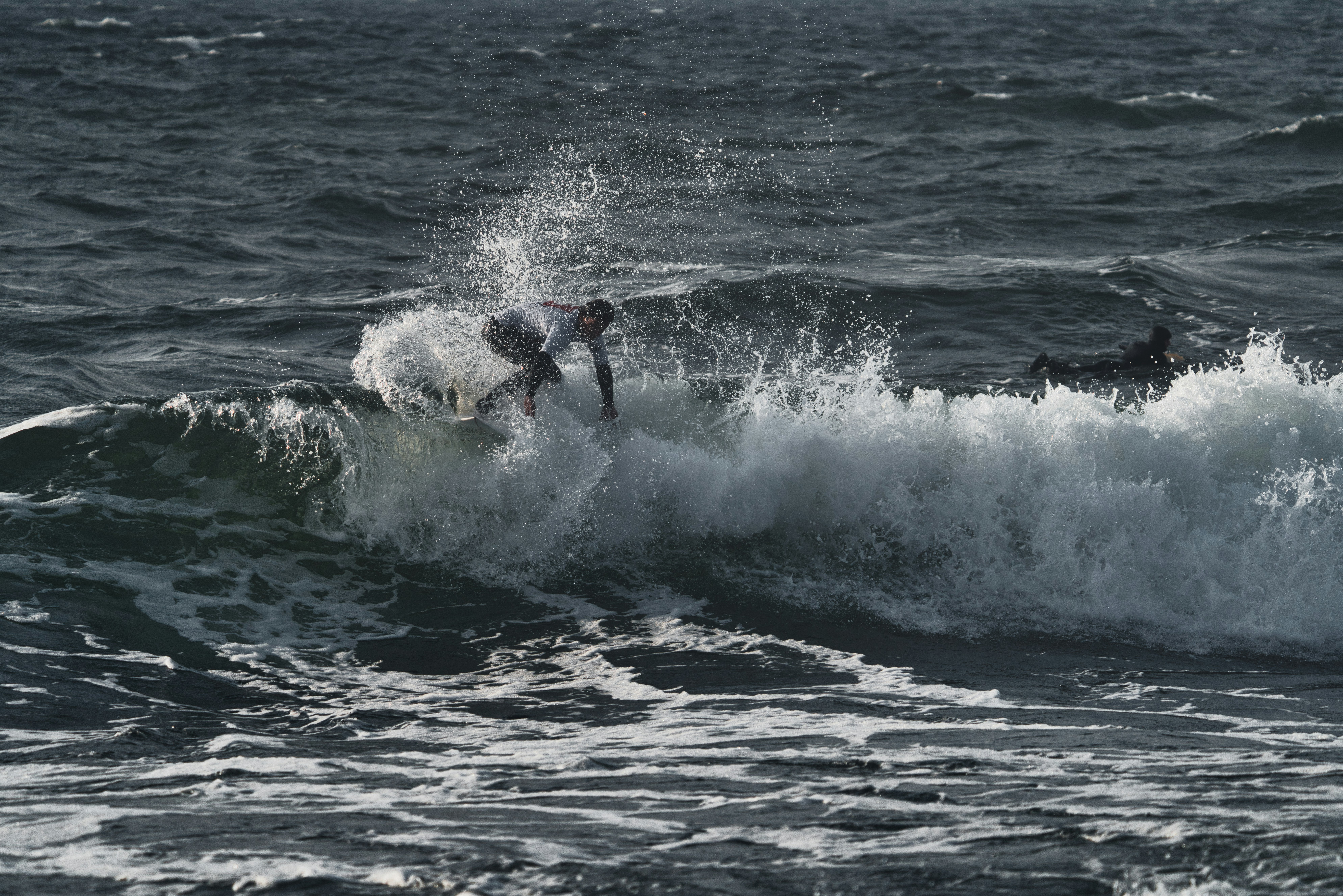 a man riding a wave on top of a surfboard
