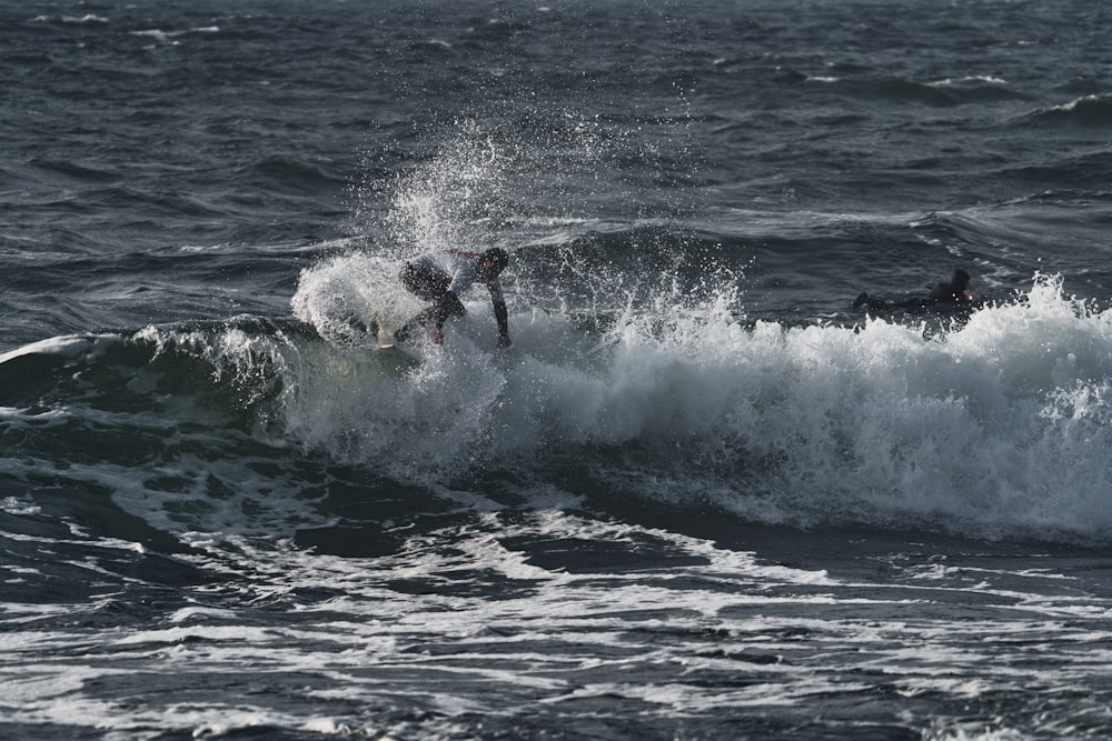 a man riding a wave on top of a surfboard