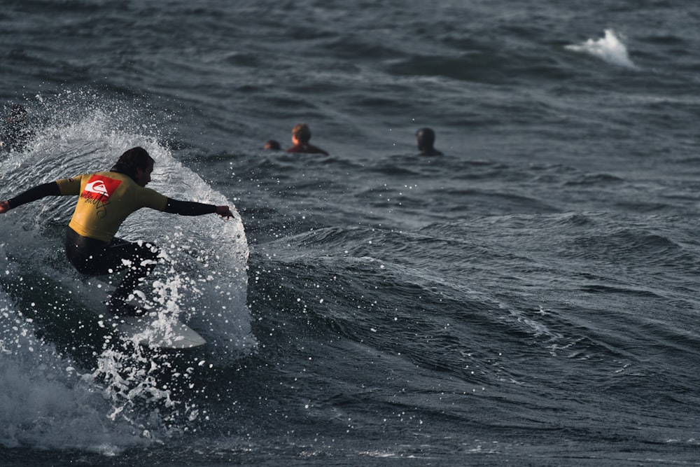 a man riding a wave on top of a surfboard