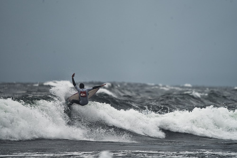 a man riding a wave on top of a surfboard