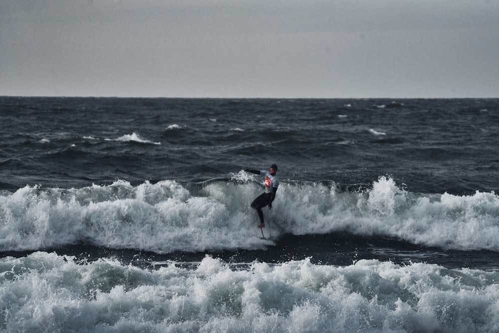 a man riding a wave on top of a surfboard