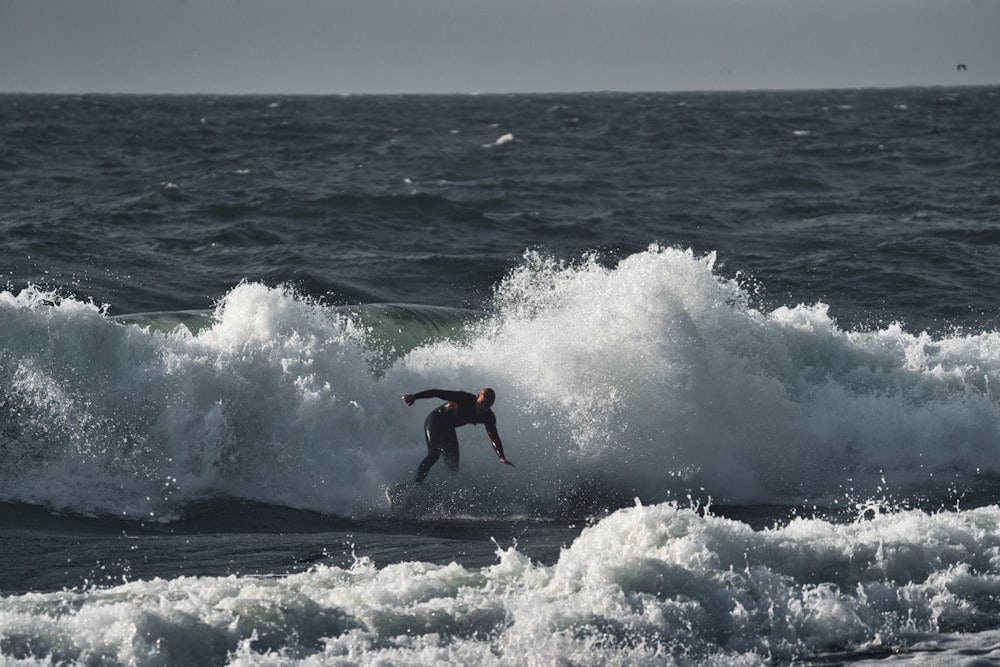 a man riding a wave on top of a surfboard