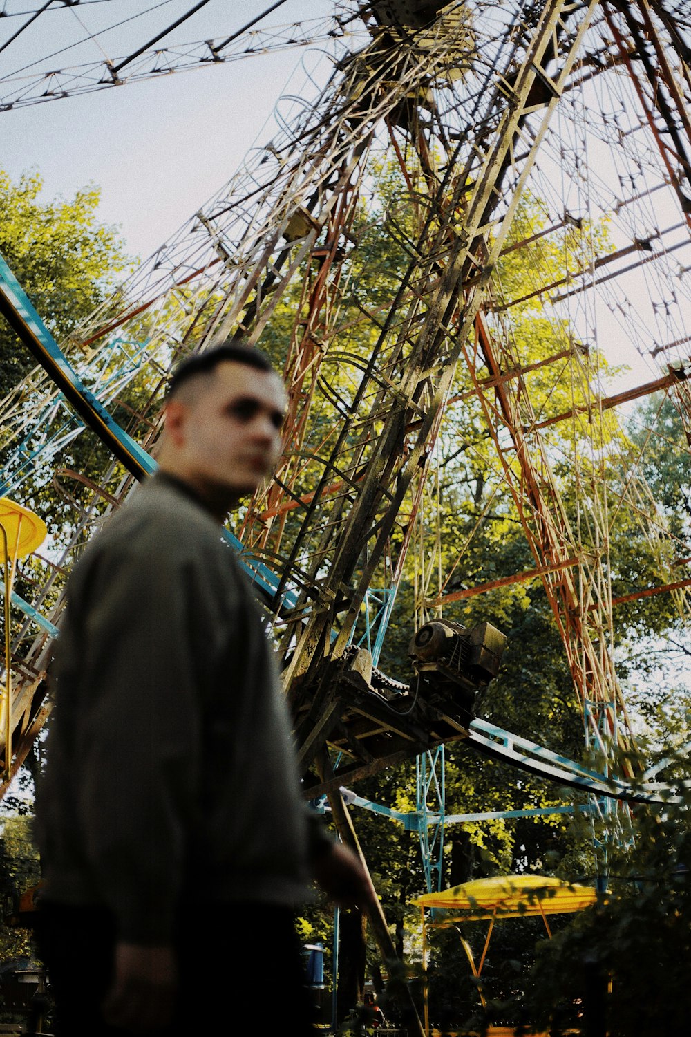 a man standing in front of a ferris wheel