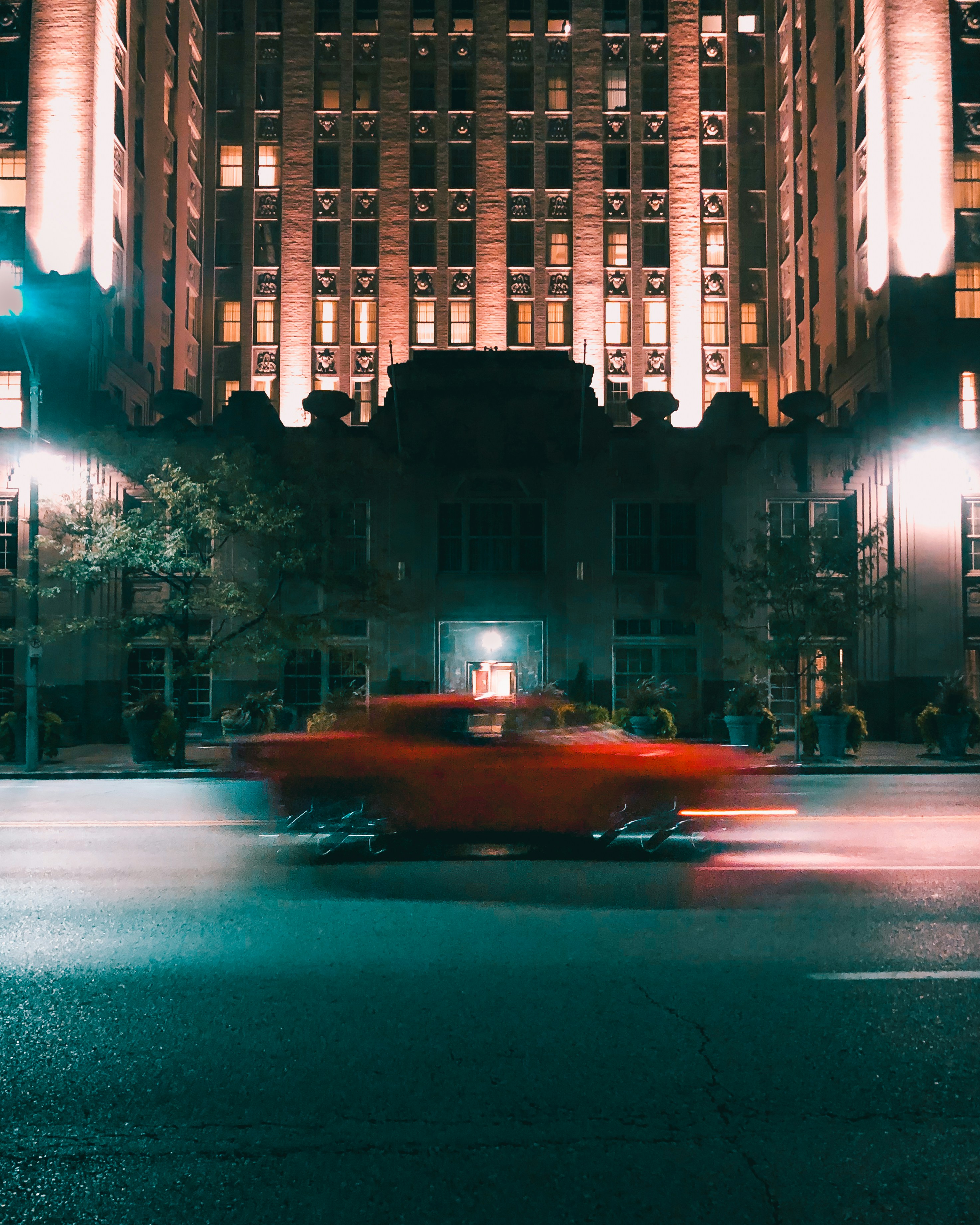 A red car driving down a city street at night photo – Free Car race ...